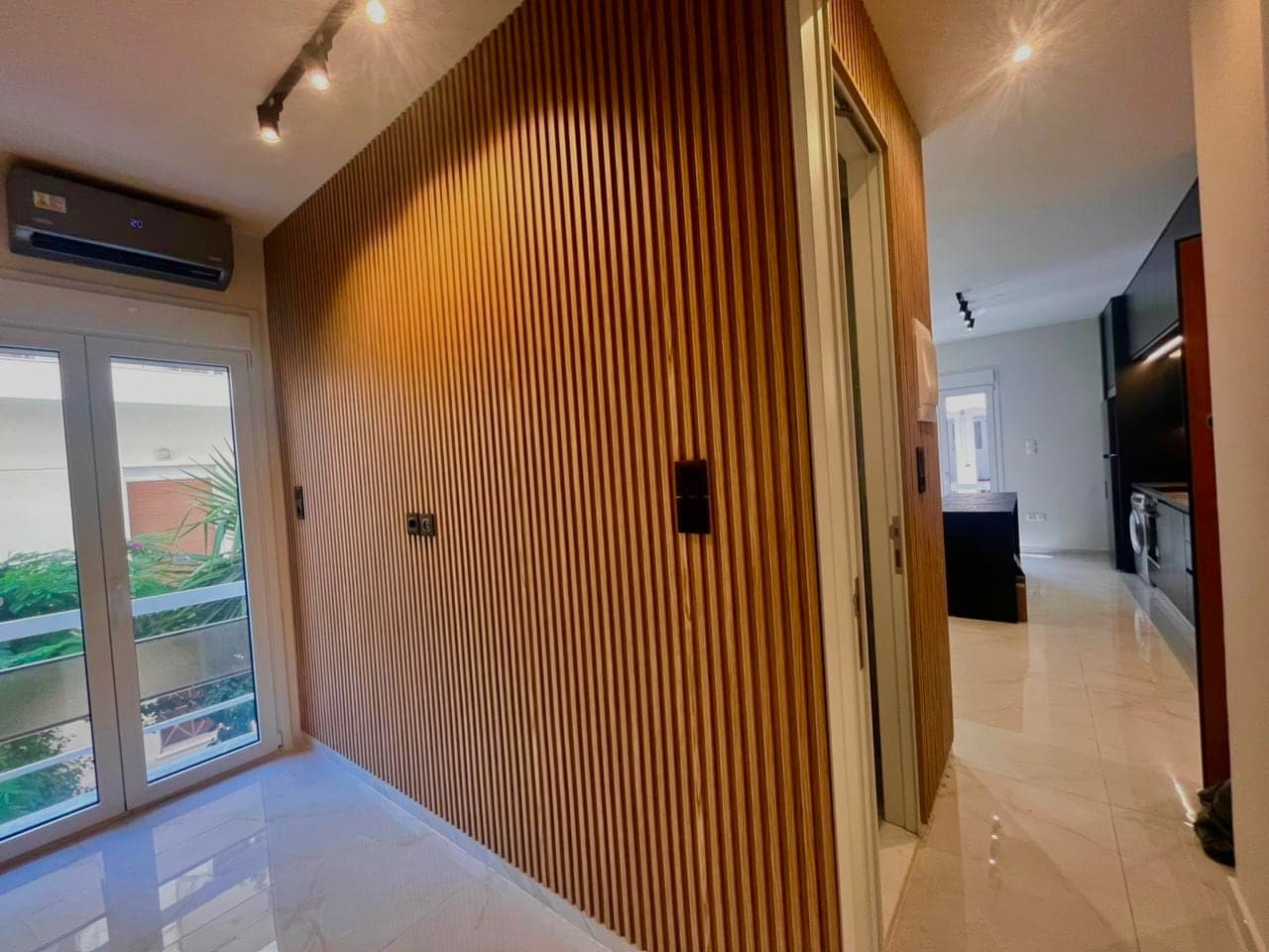 Vertical oak slat feature wall with track lighting after renovation