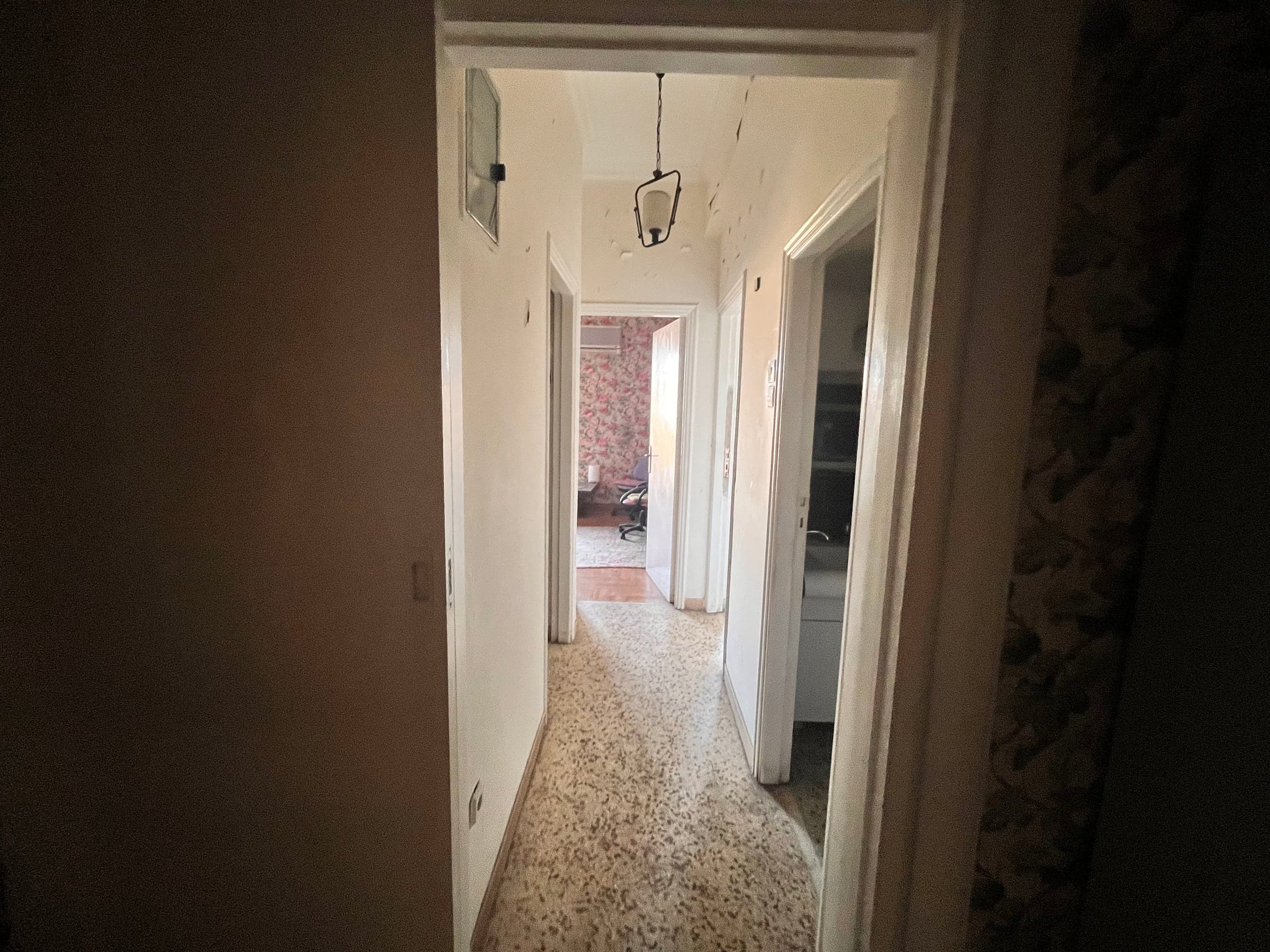 Narrow hallway before renovation with mosaic floor