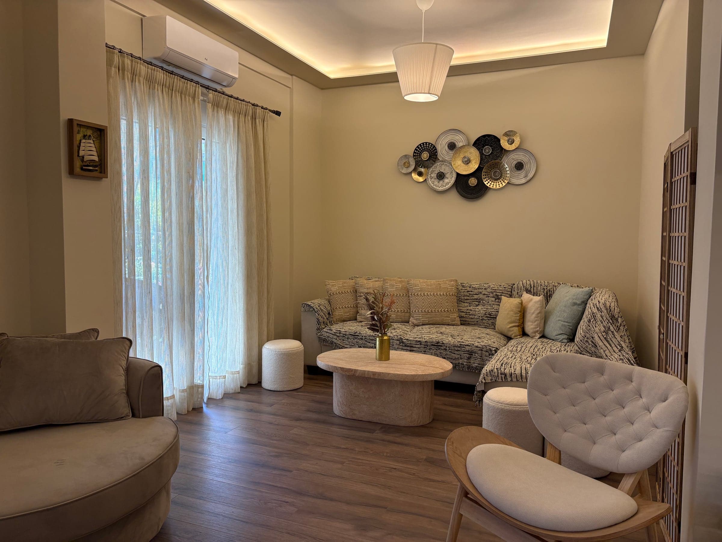 Furnished sitting area after renovation with recessed ceiling lighting and sheer curtains